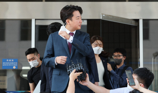 이준석 국민의힘 전 대표가 지난 8월17일 오후 서울남부지법에서 당 비상대책위원회 효력을 정지해달라며 낸 가처분 신청 사건의 심문을 마친 뒤 취재진의 질문에 답변하기 위해 마스크를 벗고 있다.<연합뉴스>